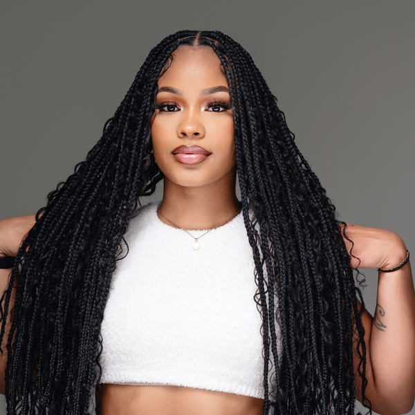 Model showcasing long black boho knotless braids, wearing a white crop top, highlighting human braiding hair.